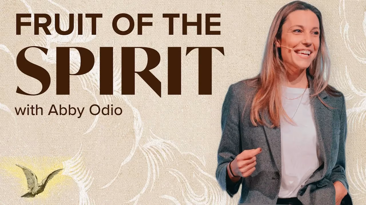 Woman smiling in gray blazer with text Fruit of the Spirit with Abby Odio. Small bird illustration visible.