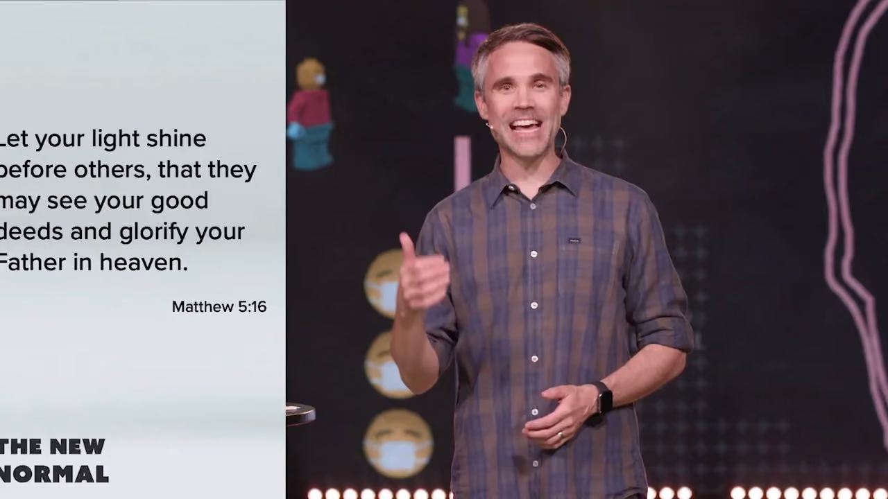 Man speaking on stage with Bible verse Matthew 5:16 displayed on screen.