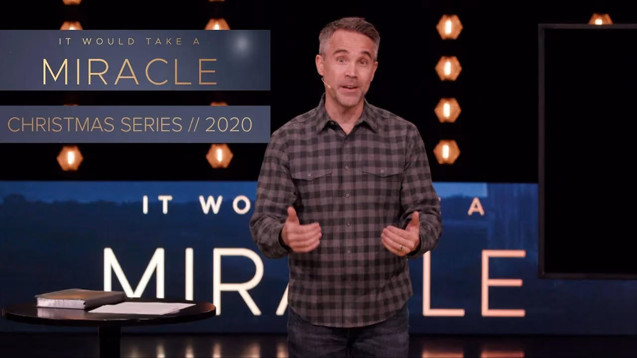 Man speaking on stage with title It Would Take A Miracle Christmas Series 2020 displayed behind him.