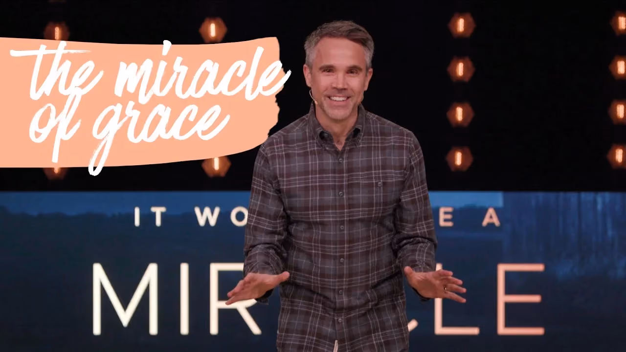 Man speaking on stage with text overlay reading the miracle of grace.