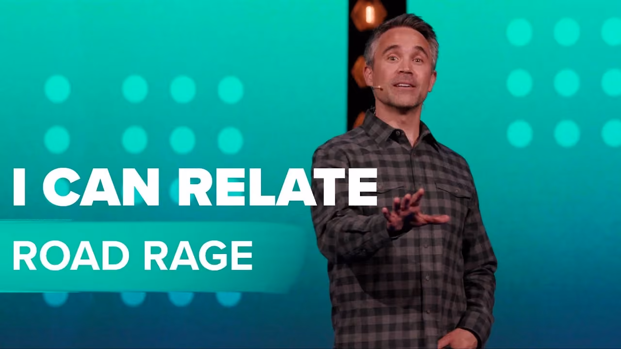 Man speaking on stage with text I Can Relate Road Rage on screen.