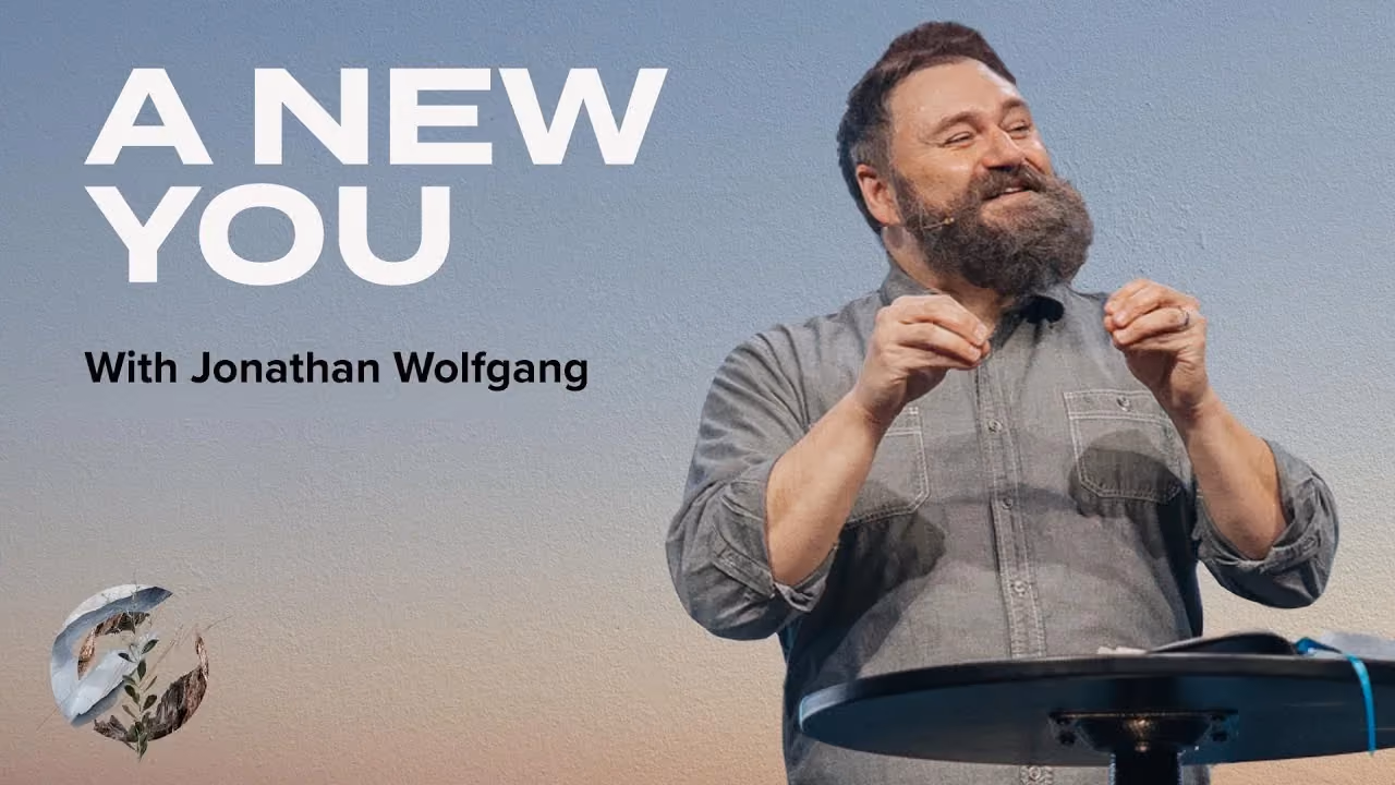 A New You with Jonathan Wolfgang, speaking at a podium under an open sky.