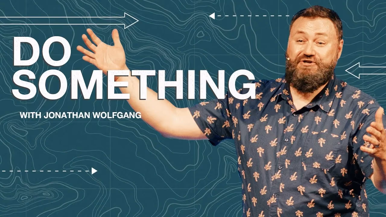 Do Something with Jonathan Wolfgang, arms open over a teal topographic map background.