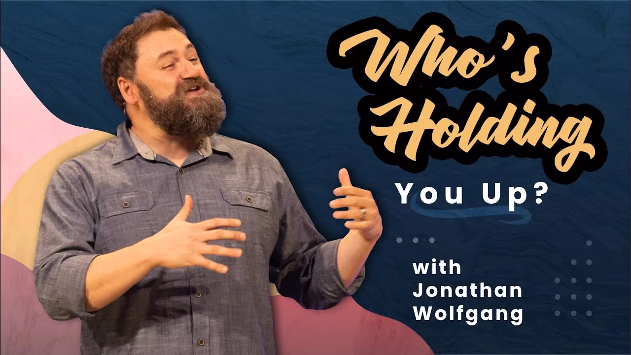 Who's Holding You Up? with Jonathan Wolfgang, hands raised mid-gesture while preaching.