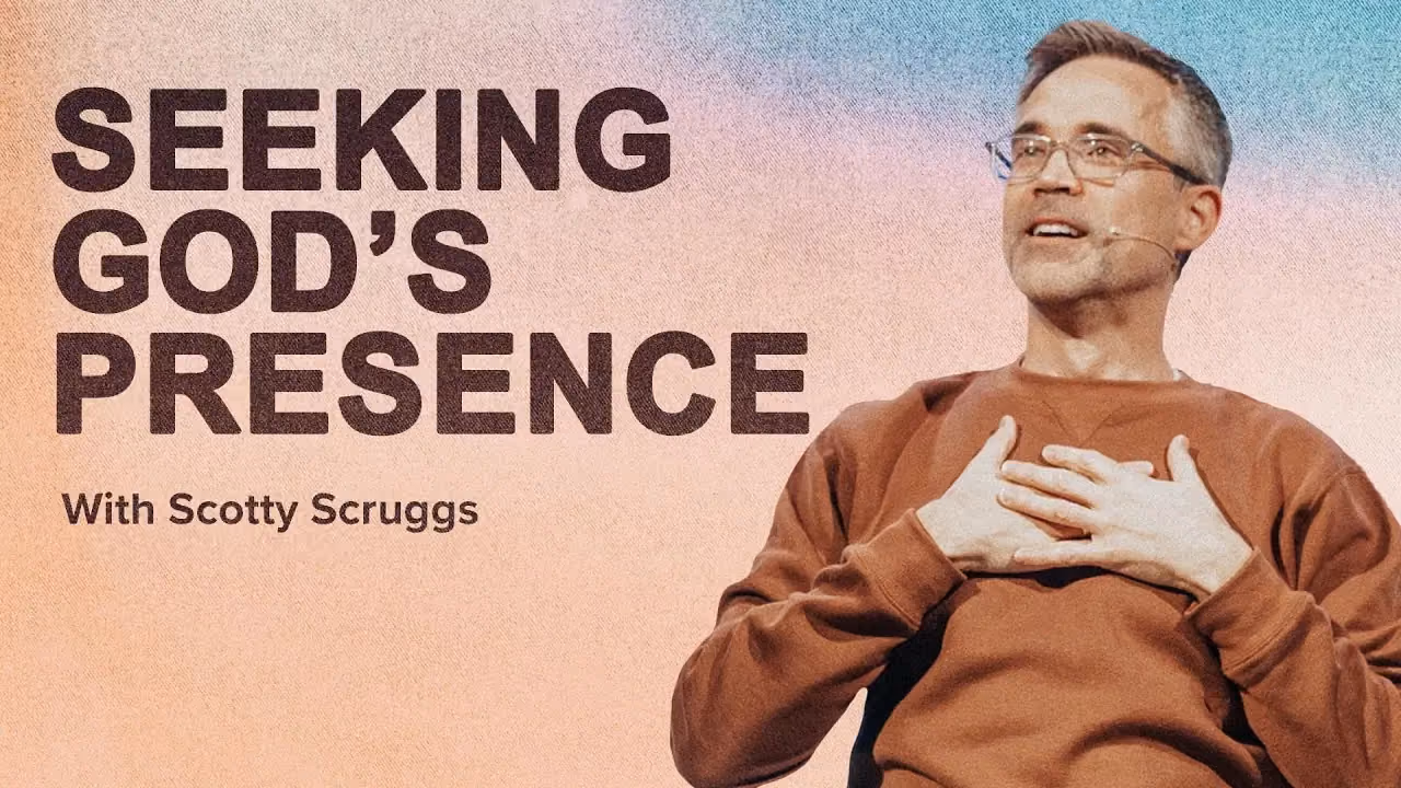 Seeking God's Presence with Scotty Scruggs, both hands on his chest in a rust sweatshirt.