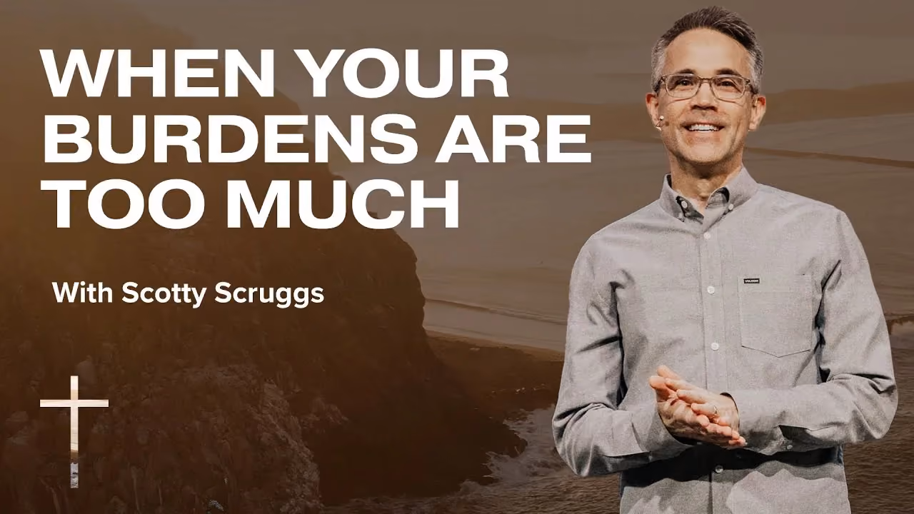 When Your Burdens Are Too Much with Scotty Scruggs, hands open in a grey shirt by a cliff.