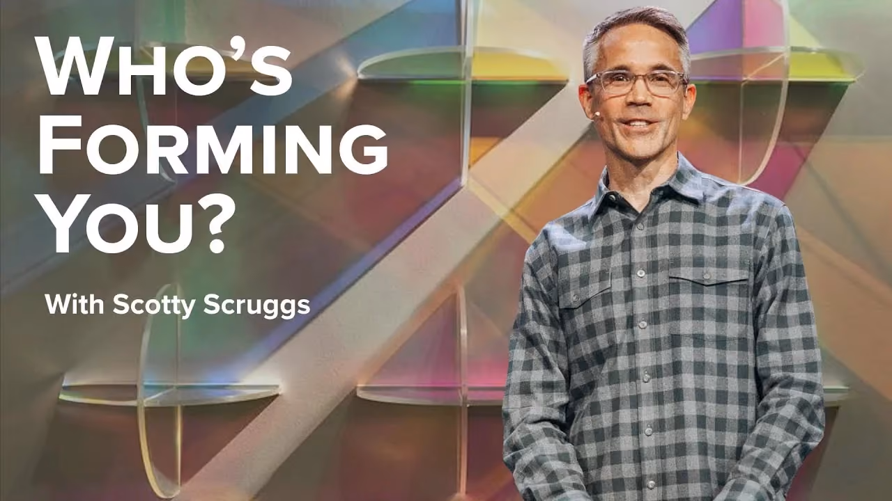 Who's Forming You? with Scotty Scruggs, in a grey plaid shirt before panels of coloured glass.