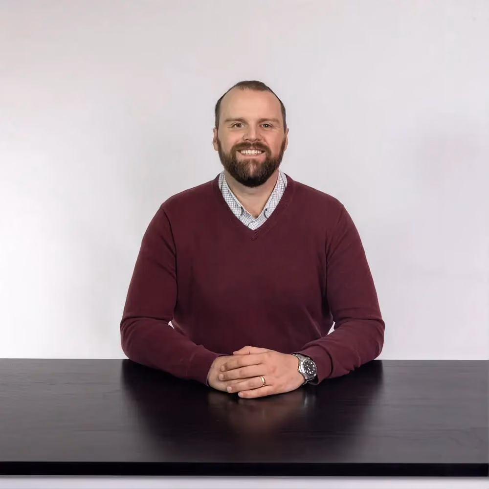 Jason Weir, Pastor of Student Ministries at Northshore Church, smiling at his desk.