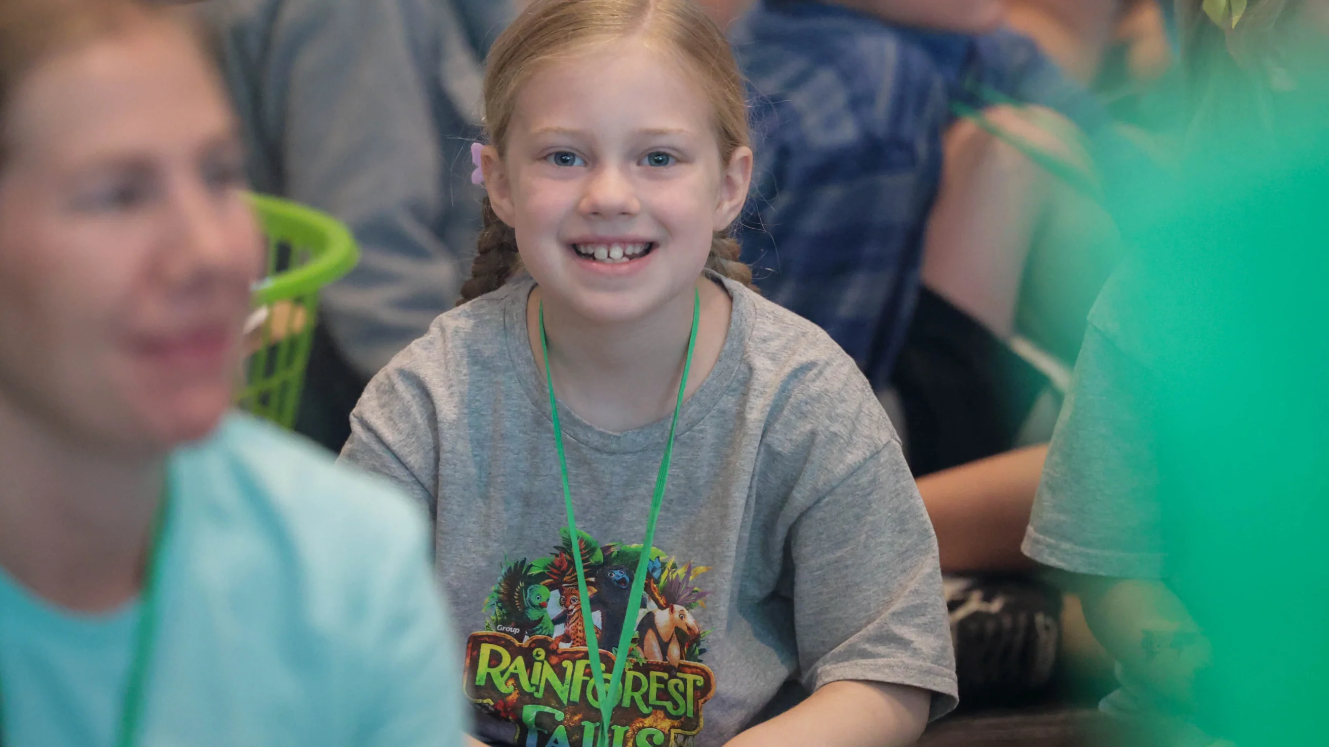A happy child wearing a rainforest-themed shirt.