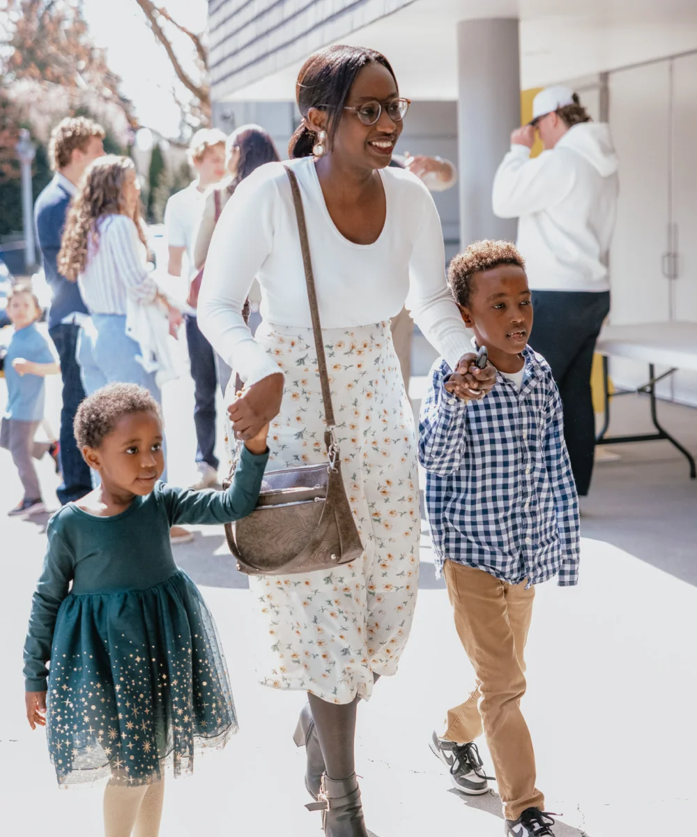 A mother and her children walking outdoors near the church.