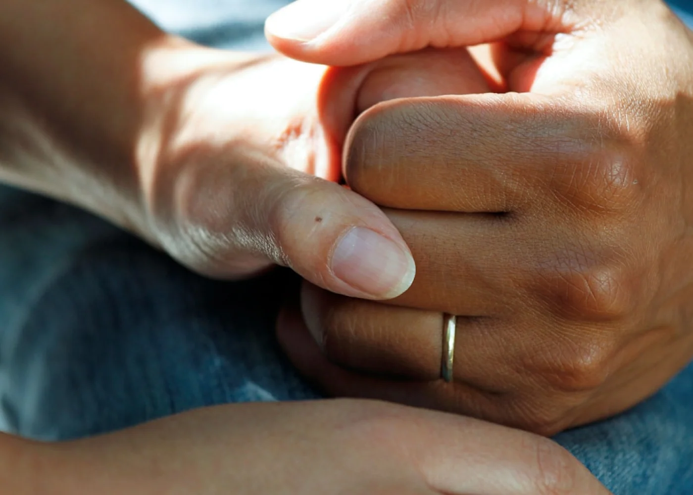 Two people's hands holding each other during an Alpha course session.