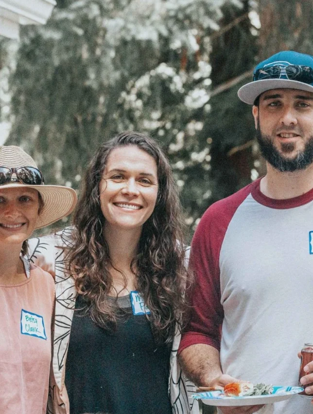 Three people smiling together outdoors at a Connect event.