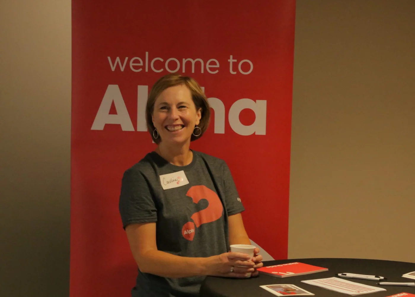 An Alpha course host welcoming guests to an event.