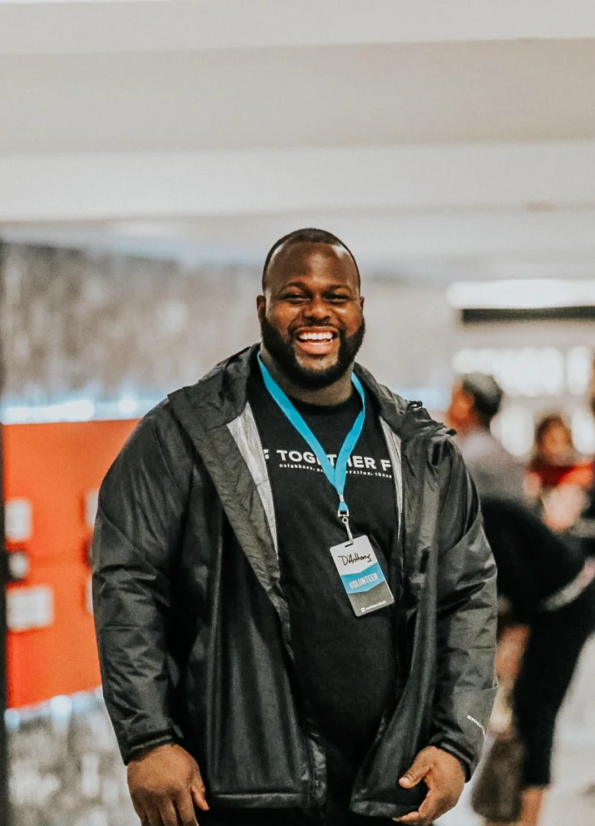 A man wearing a lanyard smiling at a Northshore Church event.