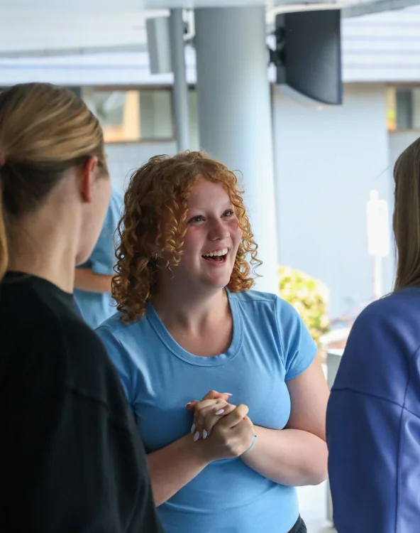 A young woman laughing with friends.