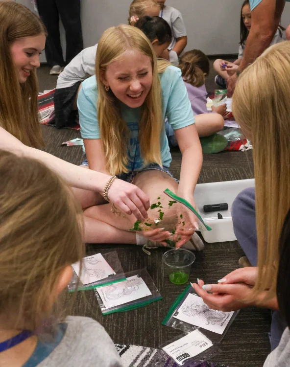 Girls making leaf art together.