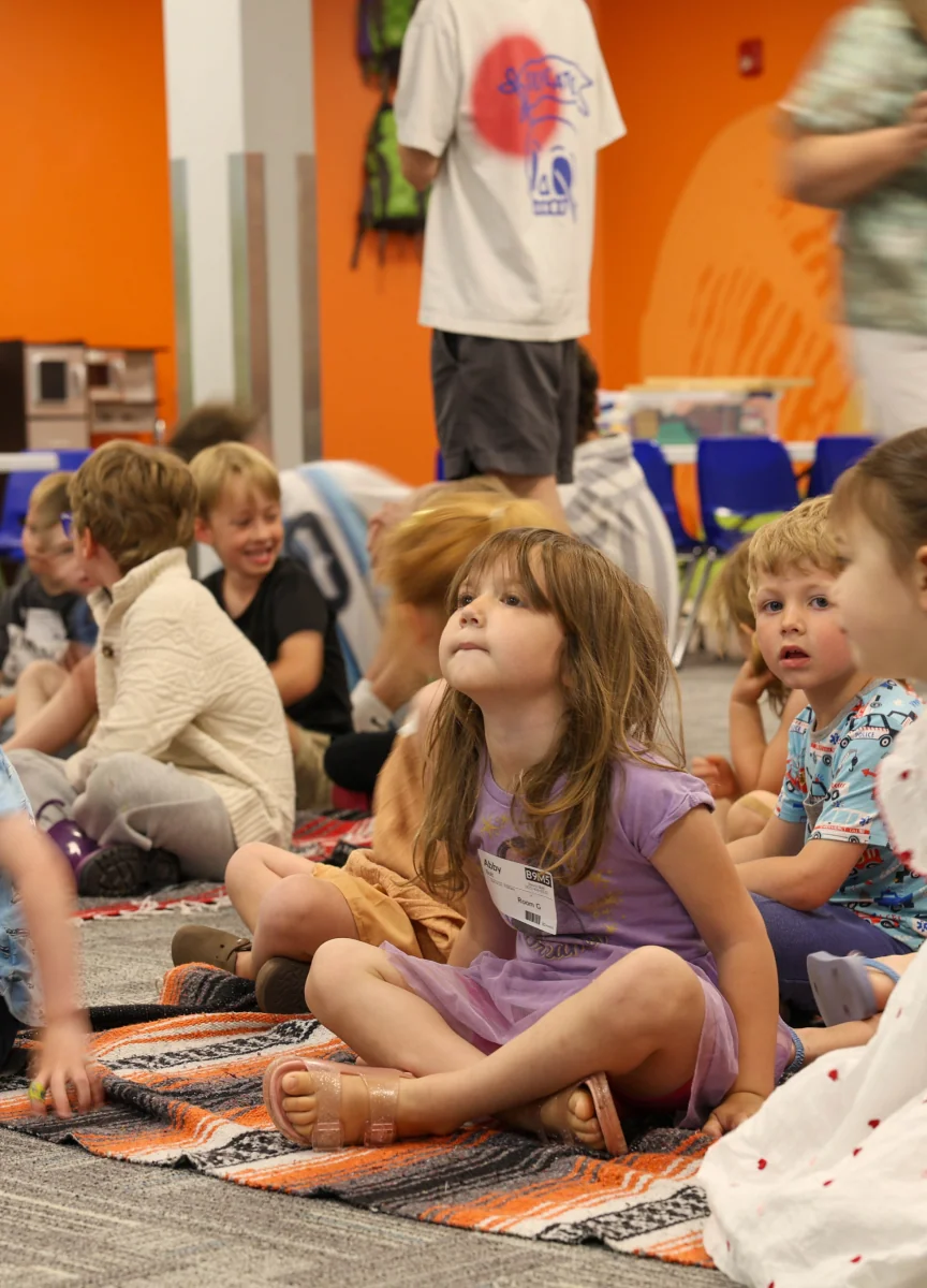 Children sitting on the floor watching a lesson.