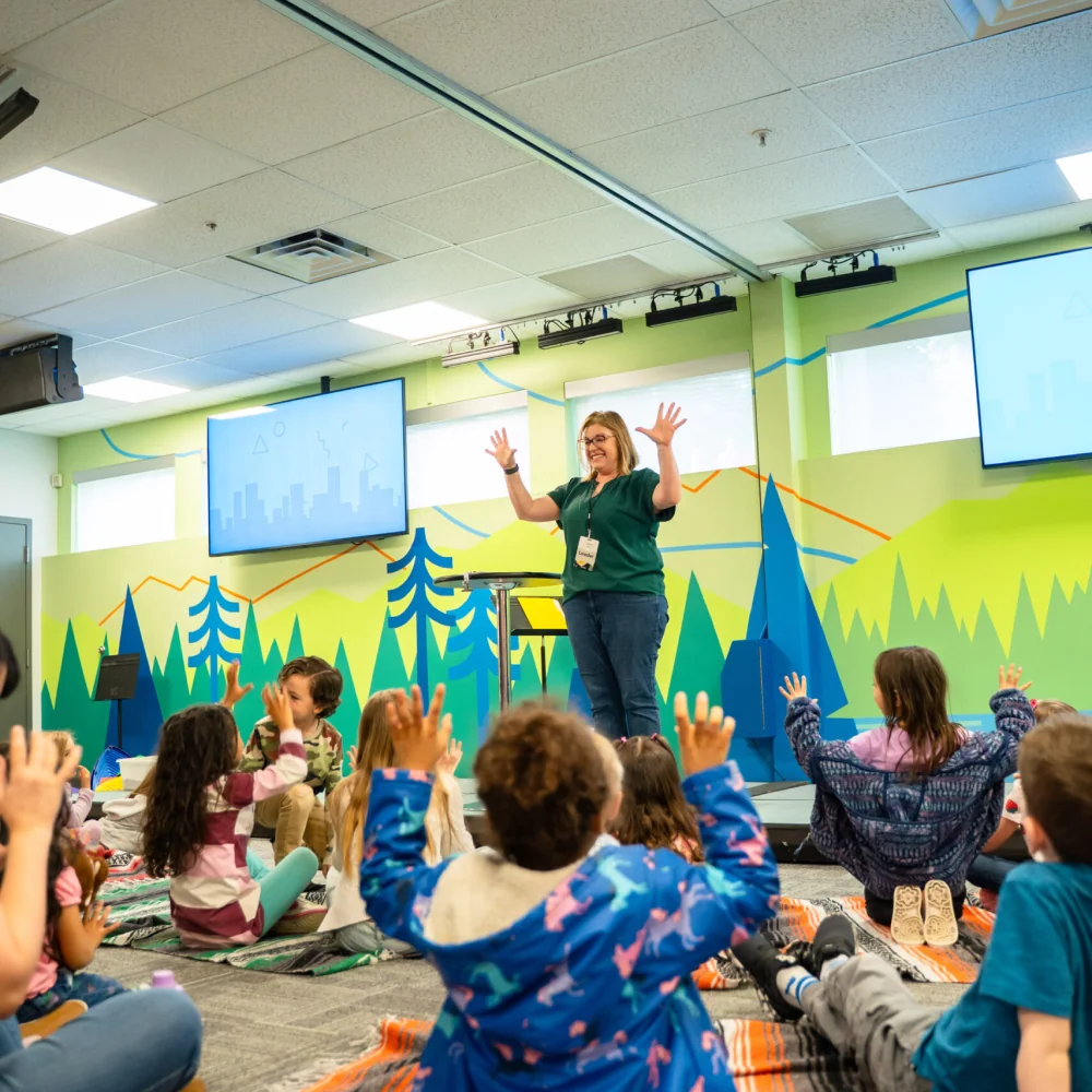 Children raising their hands in a Northshore Kids classroom.