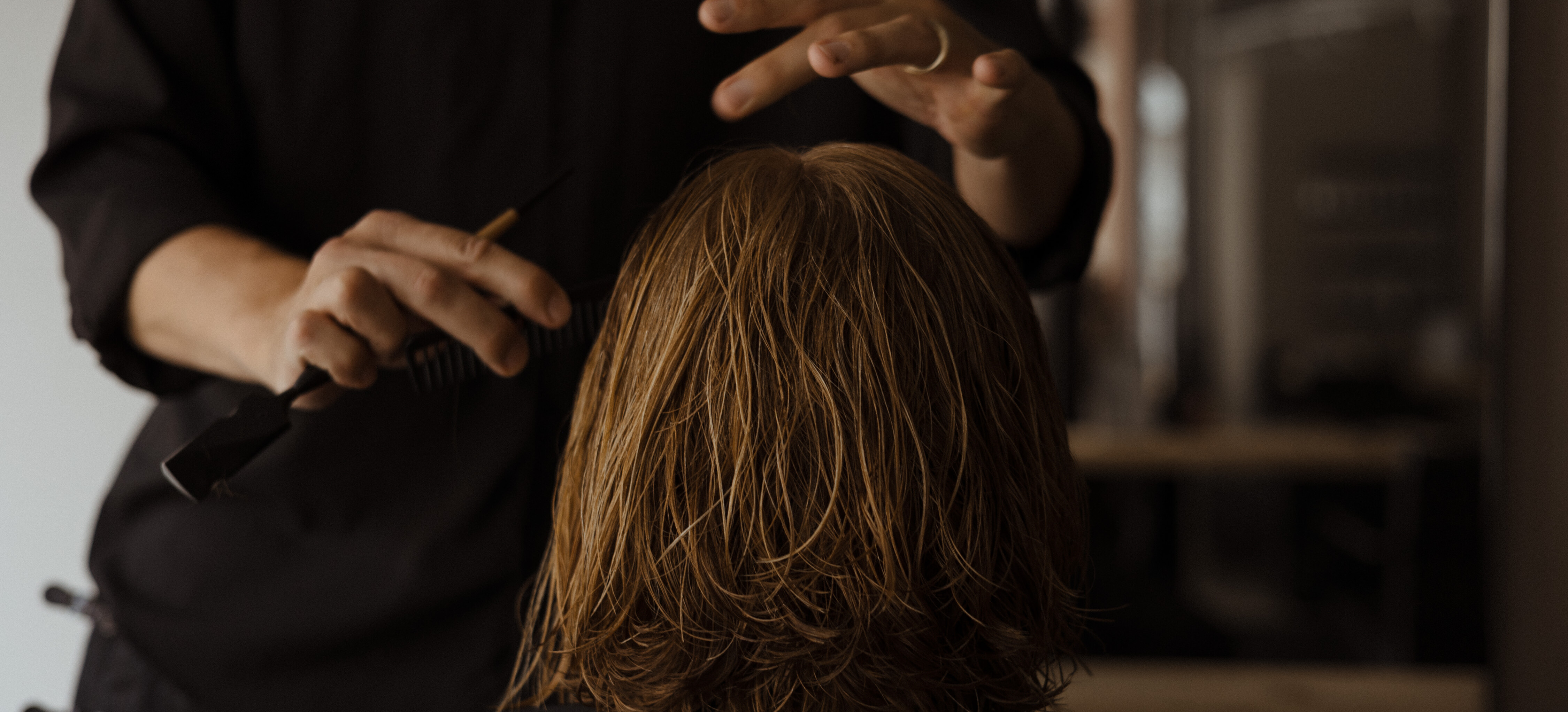 Chris Best berät und arbeitet konzentriert im Haar einer Kundin, Salon Chris Best in Mainz
