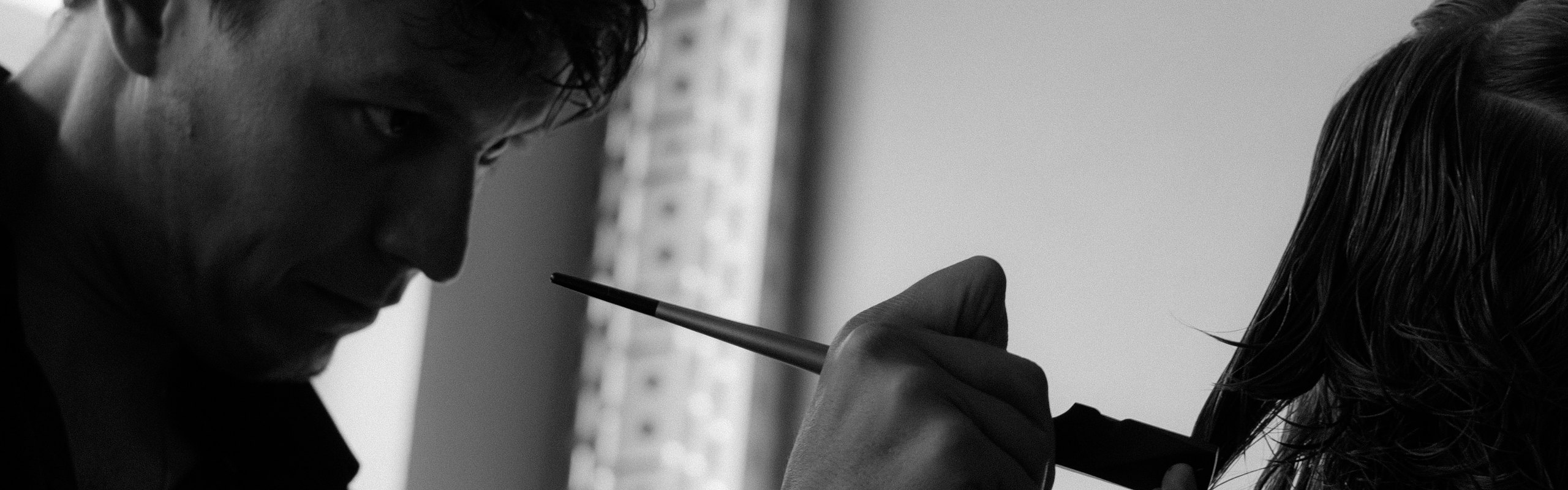 Chris Best schneidet mit dem Calligraphen eine Haarpartie im Salon in Mainz