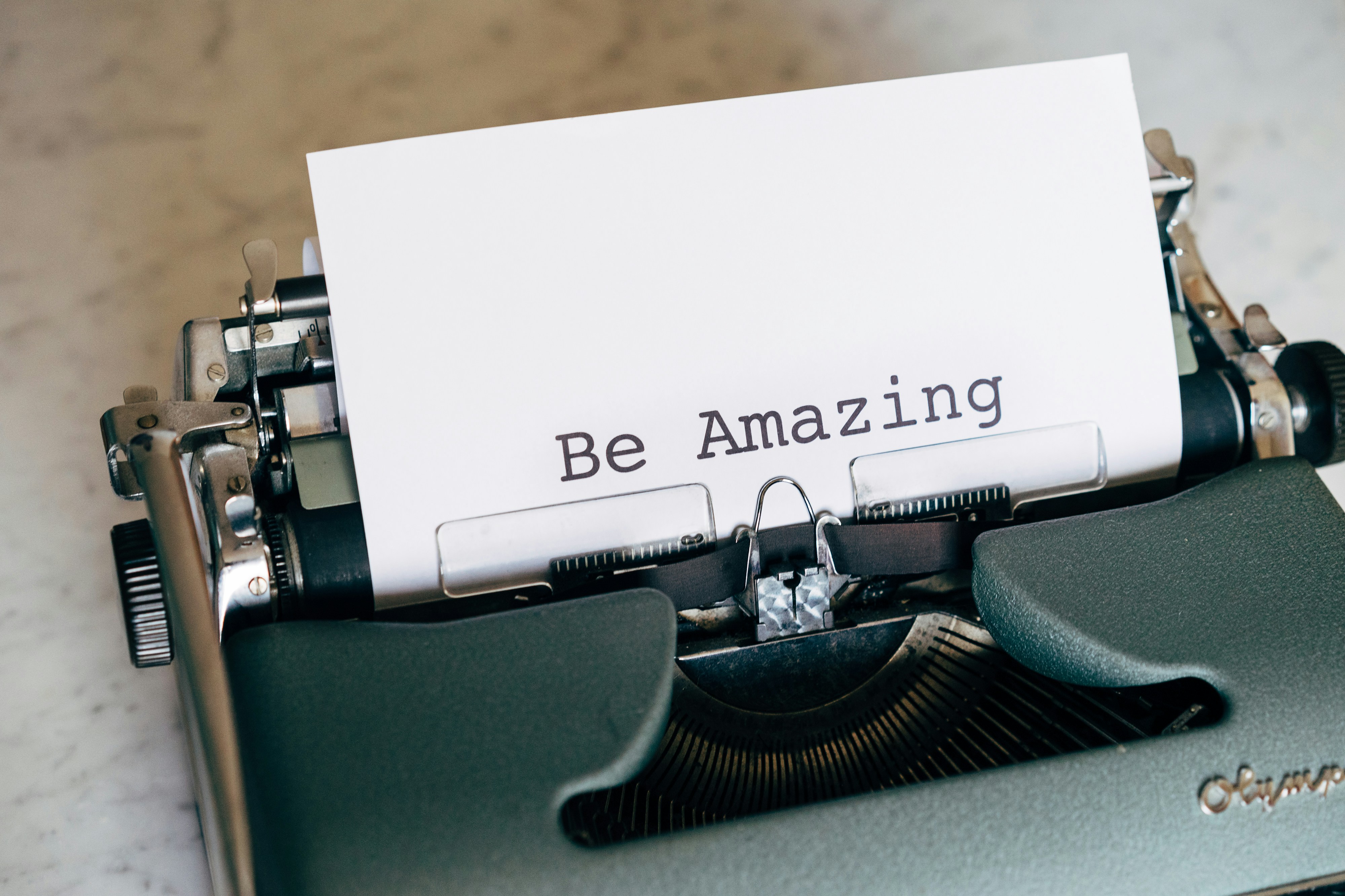 Close-up of a vintage typewriter with paper typed: Be Amazing.