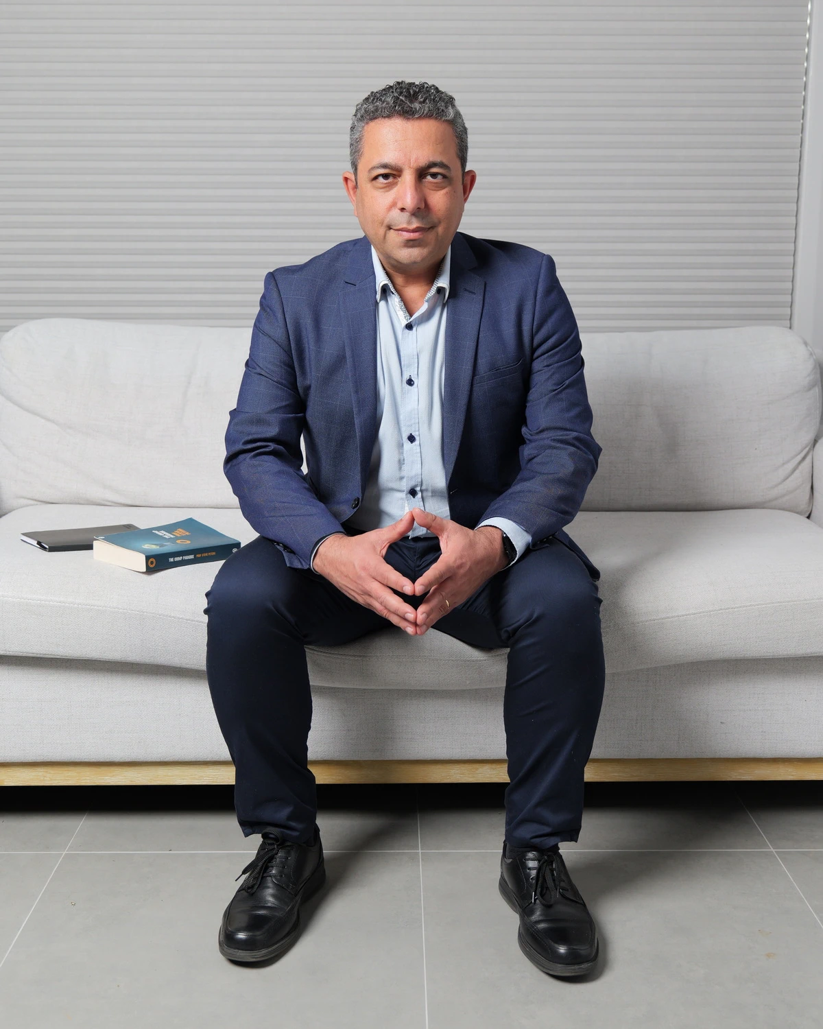 Dr Nader Malik seated on a couch
