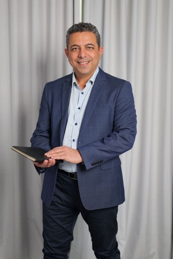 Dr Nader Malik holding a book