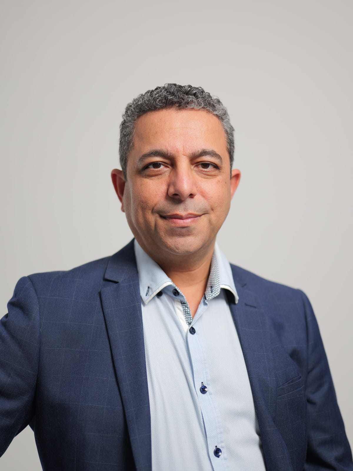 Dr Nader Malik seated in a professional portrait