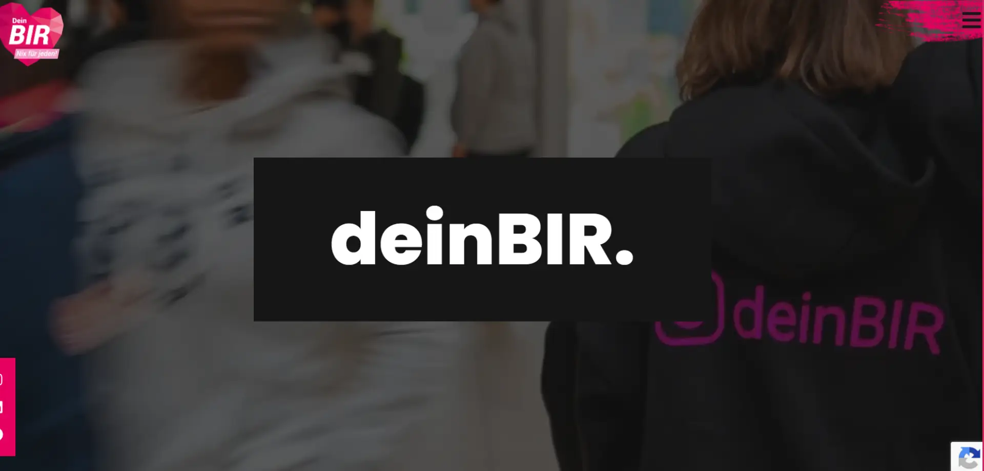 Screenshot der Website von deinBIR: Person mit schwarzem Hoodie mit pinkem Schriftzug 'deinBIR' auf dem Rücken in belebtem Innenraum.