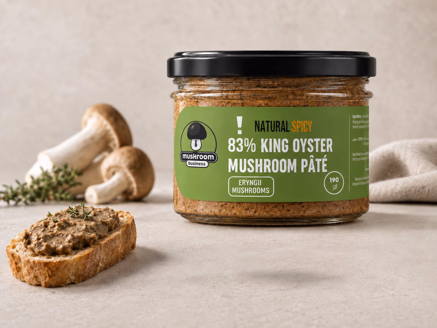 Jar of natural spicy king oyster mushroom pâté with slice of bread topped with pâté and herbs.
