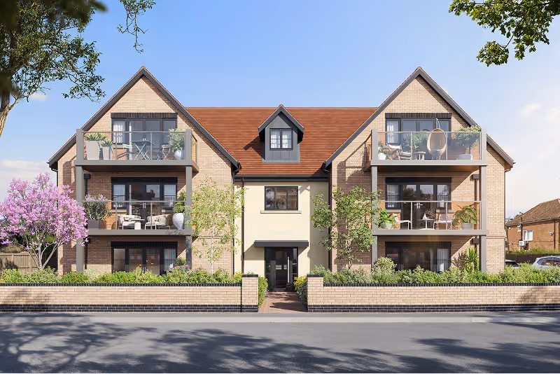 Two-story modern brick apartment building with balconies, plants, and a central entrance.
