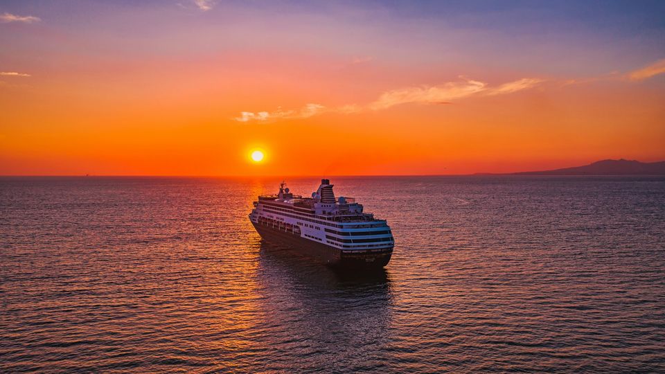 Cruise ship sailing toward the sunset