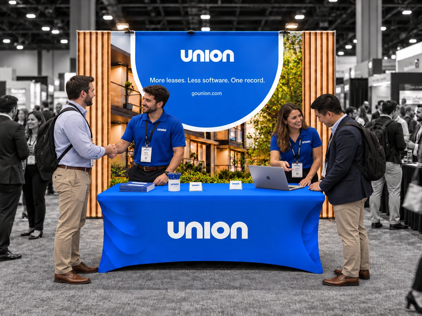 The Union booth at a trade show: a blue Union banner over a wood-slat backdrop, a blue Union table, and the Union team greeting attendees