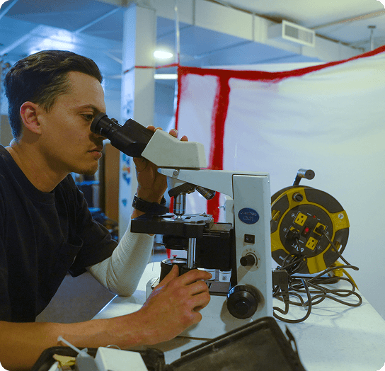 Technician examining a sample under a microscope