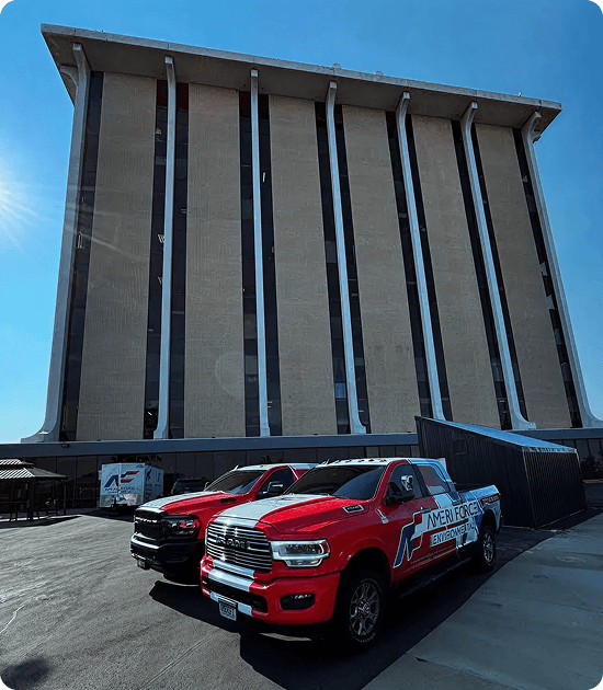Two AmeriForce trucks parked in front of a high-rise building