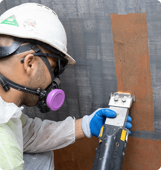 Technician in respirator removing surface material