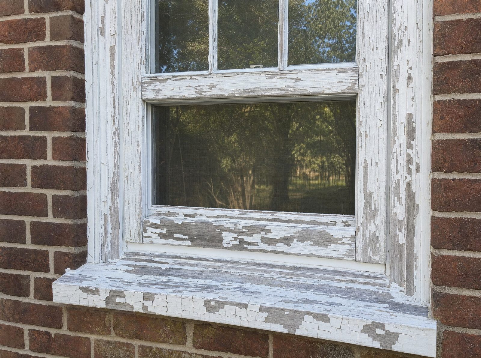 Illustrative before: peeling lead paint on a window frame