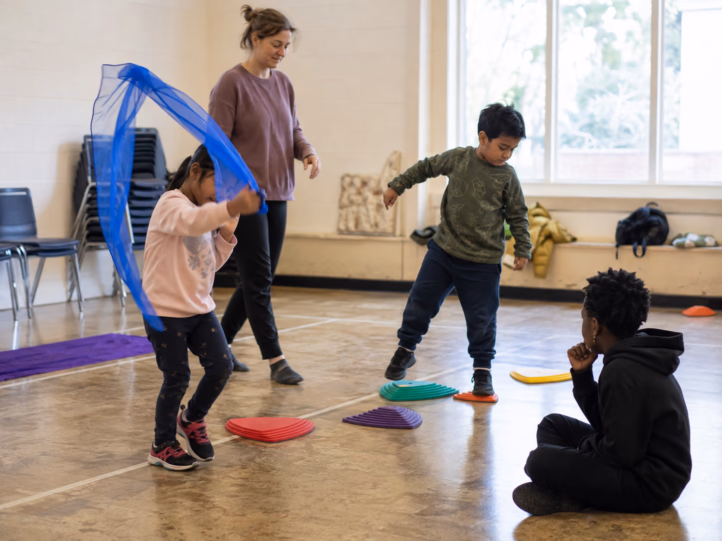 Children participating in adaptive movement and sensory-friendly play with a facilitator