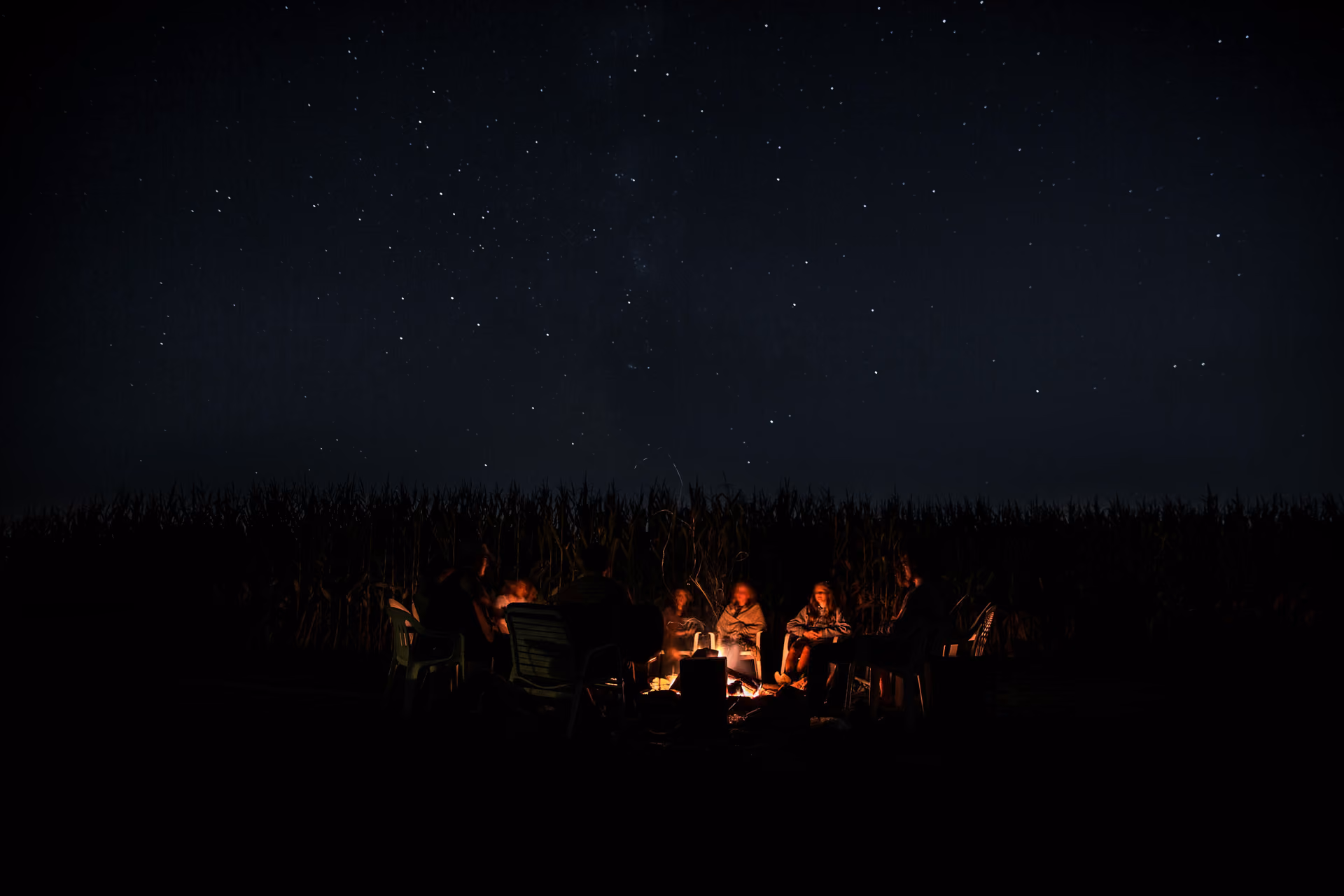 Group of people sitting around a campfire