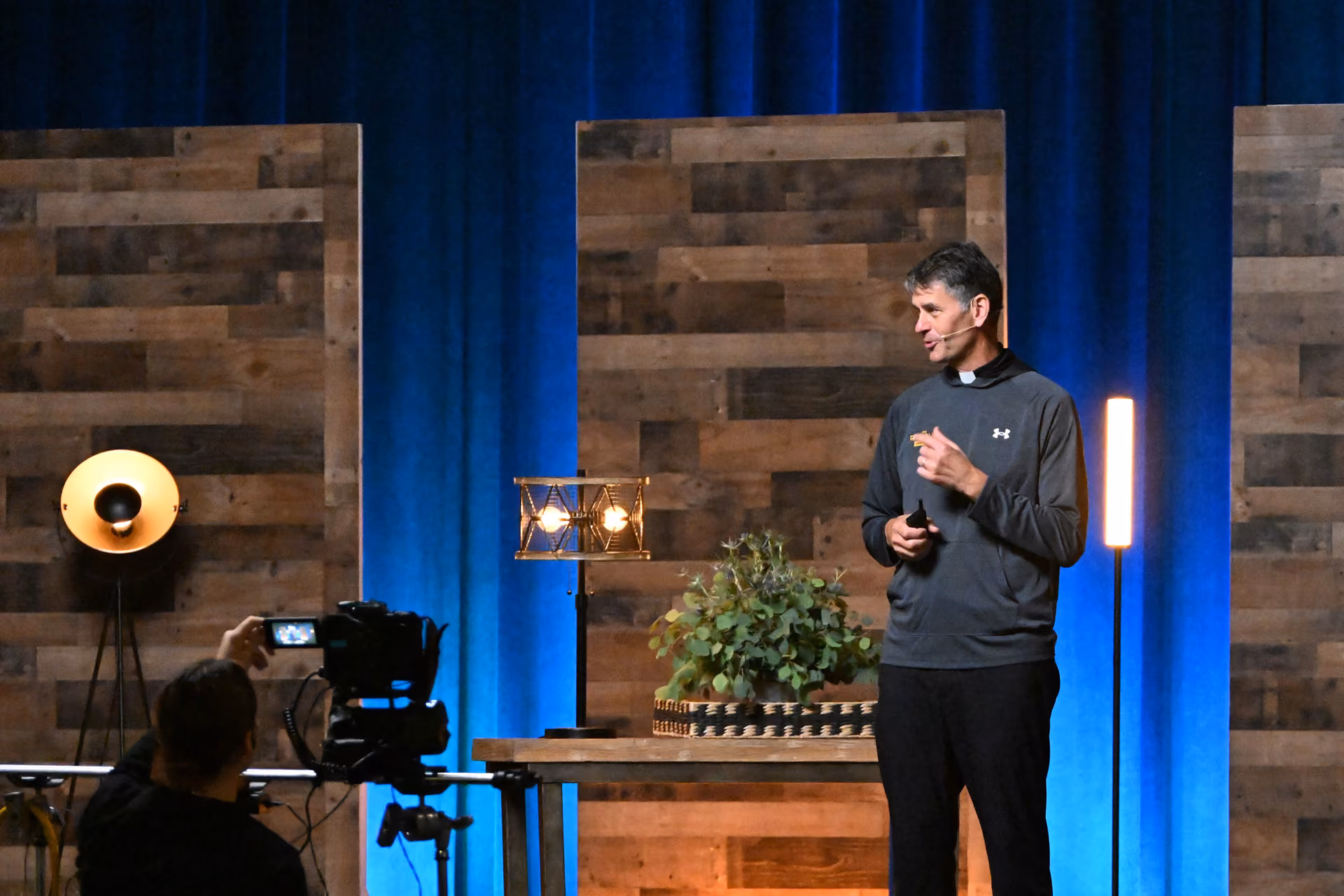 Fr. John Riccardo giving a talk on stage.
