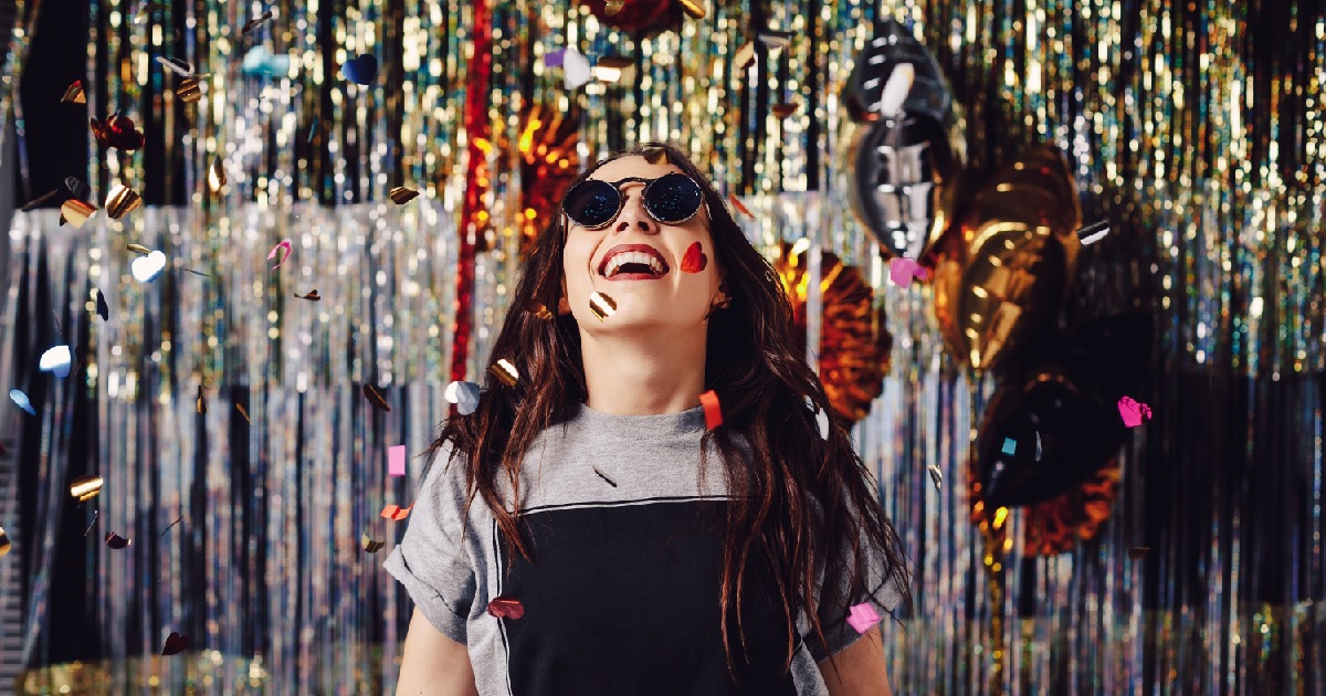 Mulher curtindo festa e confetes. Como usar dados do Carnaval no bar para planejar o ano todo