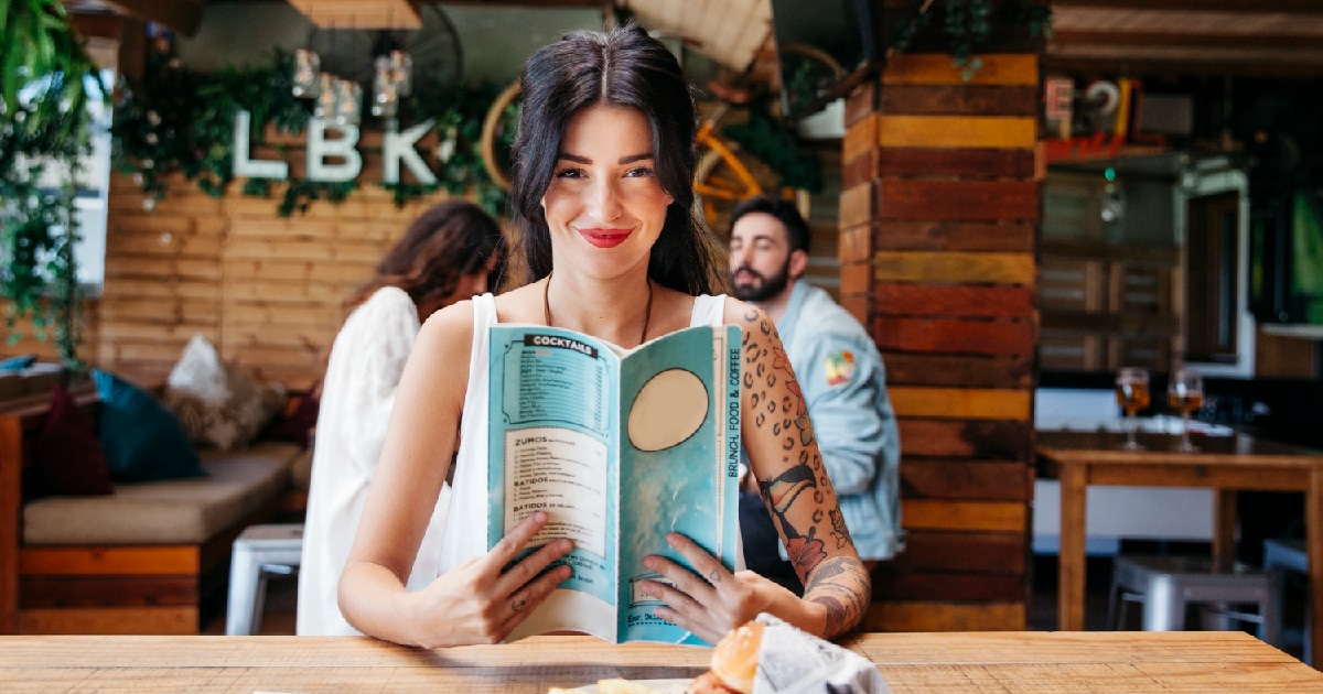 Mulher consultando menu - Construa cardápios que vendem mais