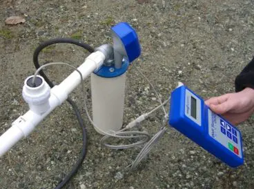 Flow-meter equipment measuring private-well pump discharge during performance testing.
