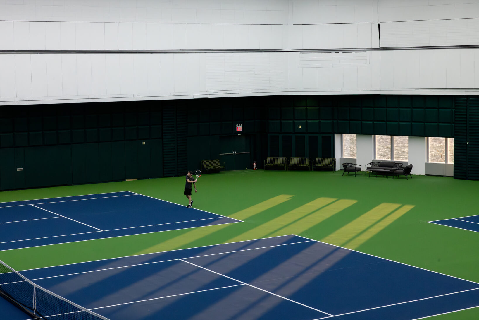 Man practicing on an empty tennis court