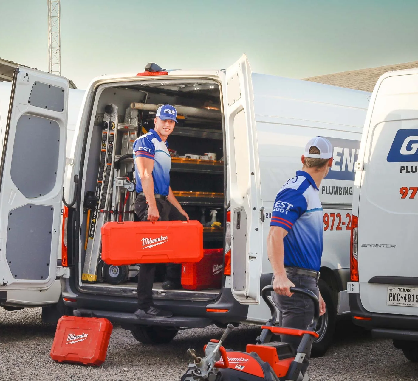 Genzel plumbers unloading tools from their work vans
