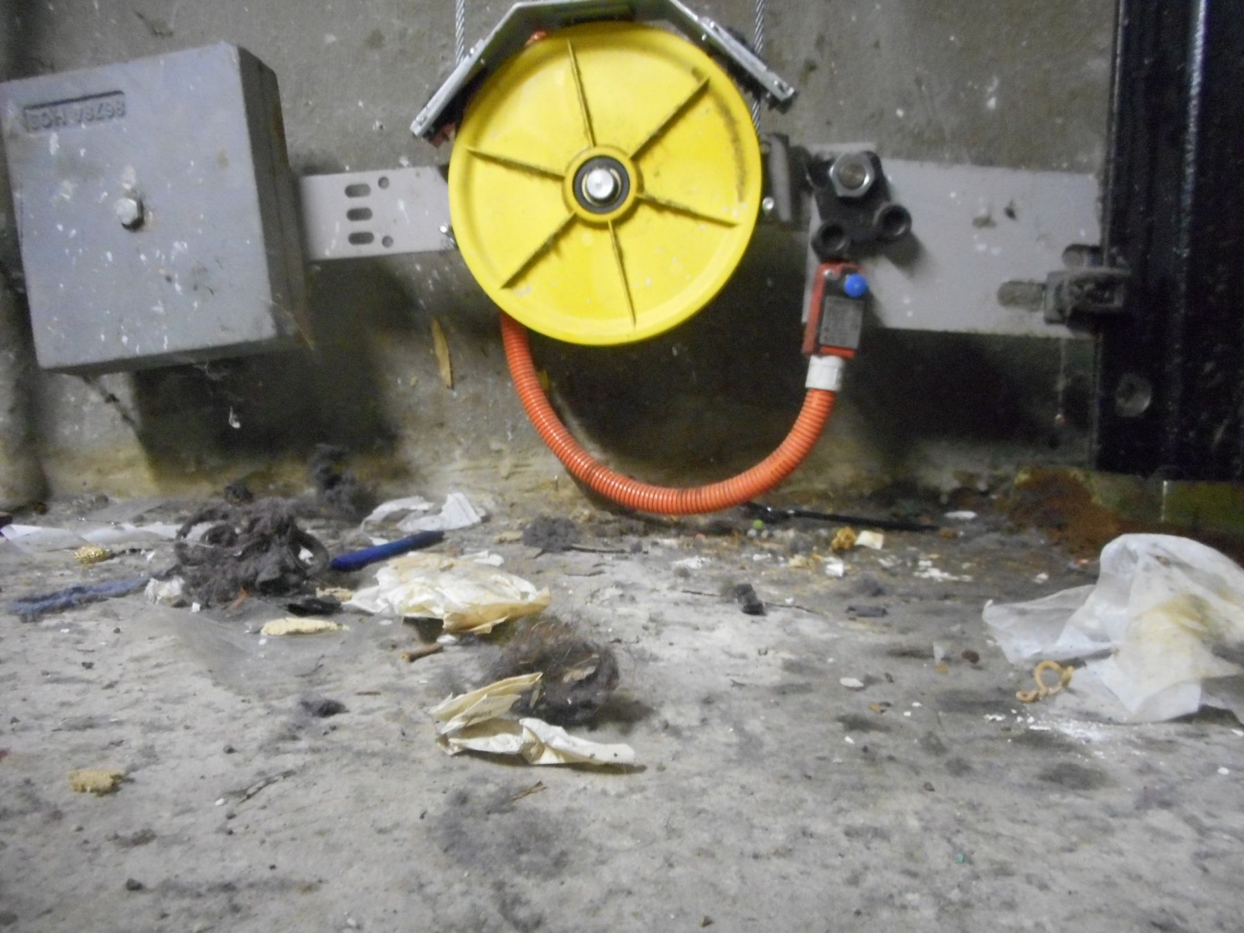 Lift machine room with oil stains and rubbish showing poor maintenance housekeeping
