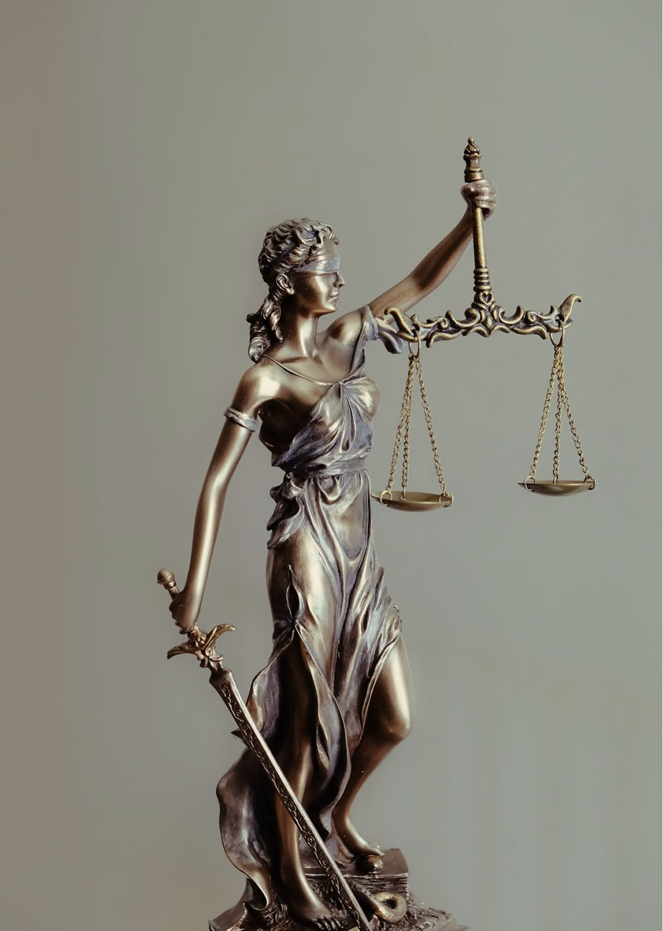 Bronze statue of blindfolded Lady Justice holding scales and sword.
