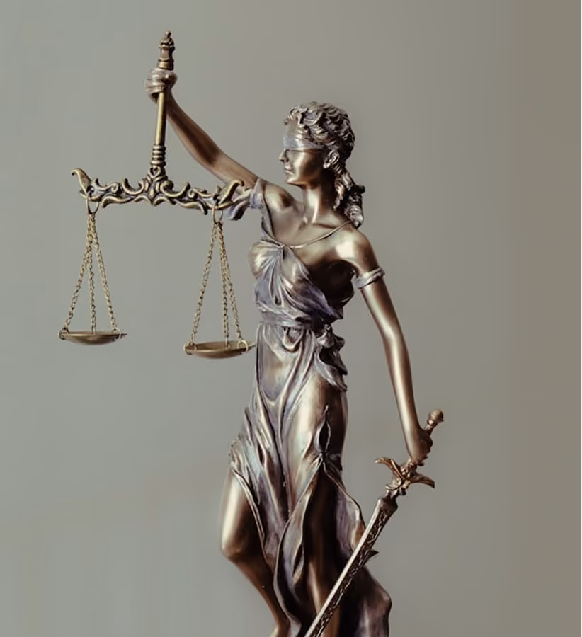 Bronze statue of blindfolded Lady Justice holding balanced scales and a sword.