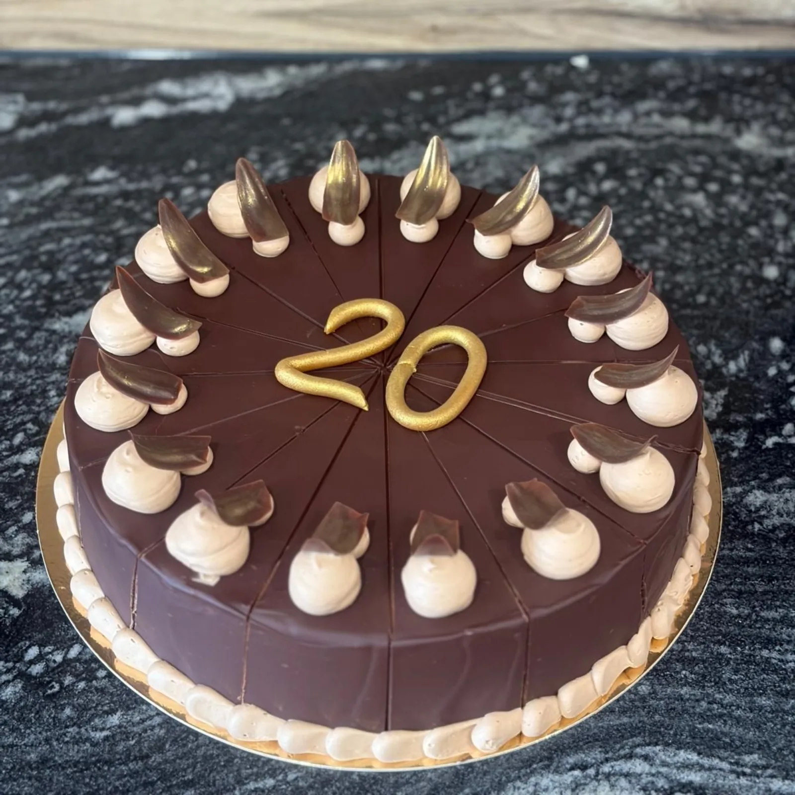 Schokoladentorte mit Sahnetupfen und goldener 20