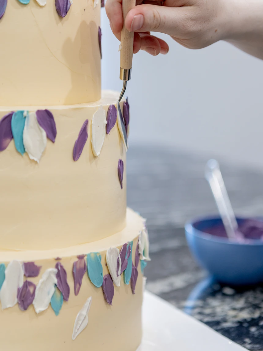 Ein einzelnes Blütenblatt wird mit dem Spritzbeutel auf die Torte gesetzt